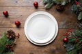 Festive Christmas Table Setting with Empty White Plate and Holiday Decorations Royalty Free Stock Photo
