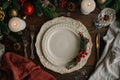 Festive Christmas Table Setting with Empty White Plate and Holiday Decorations Royalty Free Stock Photo
