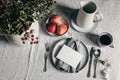 Festive Christmas table setting. Silver cutlery, bowl of apples on linen tablecloth. Cup of coffee, pitcher. Defocused