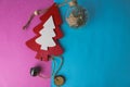 Festive Christmas winter blue pink background small toy wooden homemade cute Christmas tree and a round Christmas tree toy, a ball Royalty Free Stock Photo