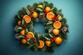 Festive Christmas wreath. Crafted from lush green tree branches, slices of citrus and red rowan berrie on textured blue wall.