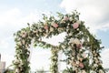 A festive chuppah decorated with fresh beautiful flowers for an outdoor wedding ceremony