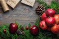 Festive colorful botanical Christmas composition. Fresh green juniper red apples pomegranates pine cones bauble gift boxes wood