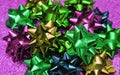 Festive colorful bows on sparkling glitter paper texture. Holiday background. Royalty Free Stock Photo