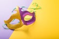 A festive, colorful group of mardi gras or carnivale mask on a yellow purple background. Venetian masks