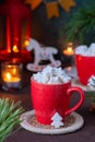 Festive composition, cocoa with star-shaped marshmallows in a red cup on a brown concrete background in Christmas style. Merry