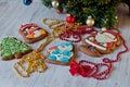 Festive composition. Honey cakes with glazed pictures laying under pie tree branch on light wooden table