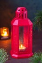 Festive composition, red metal lantern with a candle and fir branches on a brown concrete background. Merry Christmas concept Royalty Free Stock Photo