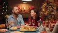 Festive couple celebrating Christmas at evening dinner table with close family members Royalty Free Stock Photo