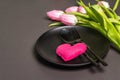 Festive creative black table setting with tulips on dark background