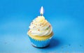 Festive cupcake with a candle on a blue background