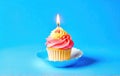 Festive cupcake with a candle on a blue background. Space for text