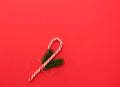 Festive decor. Caramel Christmas staff and spruce branches tied with red thread. Red background with free space for text Royalty Free Stock Photo