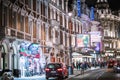 Festive decorations and Christmas lights at Leicester square and people walking on the street. London`s night life Royalty Free Stock Photo