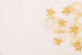 Festive decorations, gold stars curl ribbon on soft white wooden background, copy space. Royalty Free Stock Photo