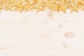 Festive decorations, gold stars on soft beige wooden background. Royalty Free Stock Photo