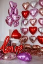 Festive decorations for Valentine's day, wedding or hen party. Love sign and heart shape balloons on white Royalty Free Stock Photo