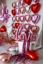 Festive decorations for Valentine's day, wedding or hen party. Love sign and heart shape balloons on white Royalty Free Stock Photo