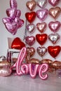 Festive decorations for Valentine's day, wedding or hen party. Love sign and heart shape balloons on white Royalty Free Stock Photo