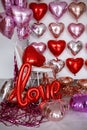 Festive decorations for Valentine's day, wedding or hen party. Love sign and heart shape balloons on white Royalty Free Stock Photo