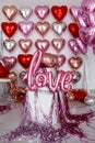 Festive decorations for Valentine's day, wedding or hen party. Love sign and heart shape balloons on white Royalty Free Stock Photo