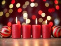 Festive decorative red burning candles and Christmas balls on the background of shiny multicolored bokeh