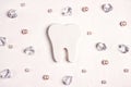 Festive dental background with tooth, crystals and beads on a white background with copy space