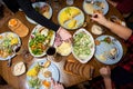 A festive dinner table, a variety of food. Hands of unknown people putting food on their plates