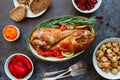 Festive dish for Thanksgiving, roasted turkey legs with vegetables on a table with snacks.