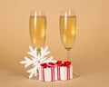 Festive drink in glasses, boxes with gifts and snowflake on beige Royalty Free Stock Photo