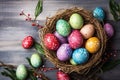 Festive Easter background with colored eggs in the nest on a wooden table