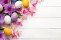 Festive Easter background with colored eggs and spring flowers on a white wooden table