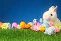 Festive Easter background with rabbit, flowers, and colorful egg