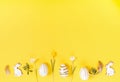 Festive Easter border, frame from easter eggs and spring flower crocus on yellow background. Stylish easter flat lay Royalty Free Stock Photo