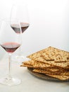 Festive Easter composition - a stack of traditional Jewish matzah bread on a plate and two glasses with red wine on a light Royalty Free Stock Photo