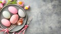 Festive Easter eggs on plate, spring flowers, grey table, holiday dinner Royalty Free Stock Photo