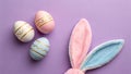 A festive Easter scene with decorated eggs and bunny ears on a purple background Royalty Free Stock Photo