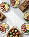 Festive easter table with colored eggs, sliced sausages, boiled eggs, and whole-grain bread Royalty Free Stock Photo