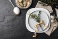 Festive Easter table setting with eggs and floral decoration on dark background, flat lay Royalty Free Stock Photo