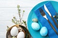Festive Easter table setting with eggs and floral decoration on wooden background, flat lay Royalty Free Stock Photo