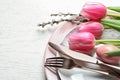 Festive Easter table setting with flowers on wooden background, above view. Royalty Free Stock Photo