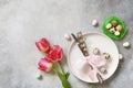 Festive Easter table setting with painted eggs, spring flowers and cutlery on light grey tabletop. Table setting for Happy Easter Royalty Free Stock Photo