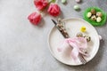 Festive Easter table setting with painted eggs, spring flowers and cutlery on light grey tabletop. Table setting for Happy Easter Royalty Free Stock Photo