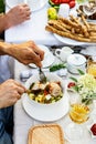 A festive family dinner or barbecue in the summer garden. Family leisure and celebration and food concept. People are eating Royalty Free Stock Photo