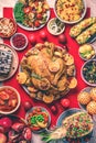 Festive family dinner. Top view. Roasted Christmas chicken with orange slices, cranberries, garlic, festive decoration, candles, Royalty Free Stock Photo