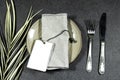 Festive fashion table setting. On the plate is a personal invitation with palm leaf.