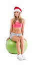 Festive fit blonde sitting on exercise ball Royalty Free Stock Photo