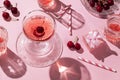 Festive flat lay with cherries drinks and a gift box, all in pink color