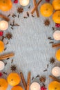 Flat lay Christmas frame of oranges, spices, and candles