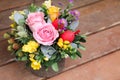 Festive flower arrangement of pink roses, yellow freesia flowers, eucalyptus leaves and other plants with red Easter eggs Royalty Free Stock Photo